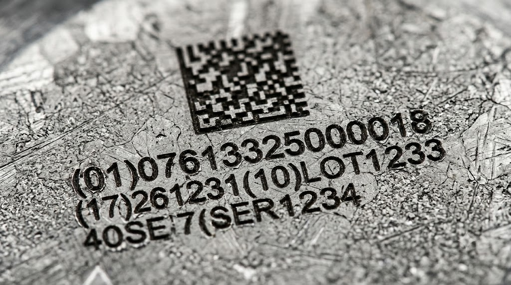 Microscopic view of CNC engraved UDI code on surgical steel.